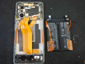Xiaomi 11T Proを背面パネルから分解し、内部のバッテリーを取り外している精密修理の様子。